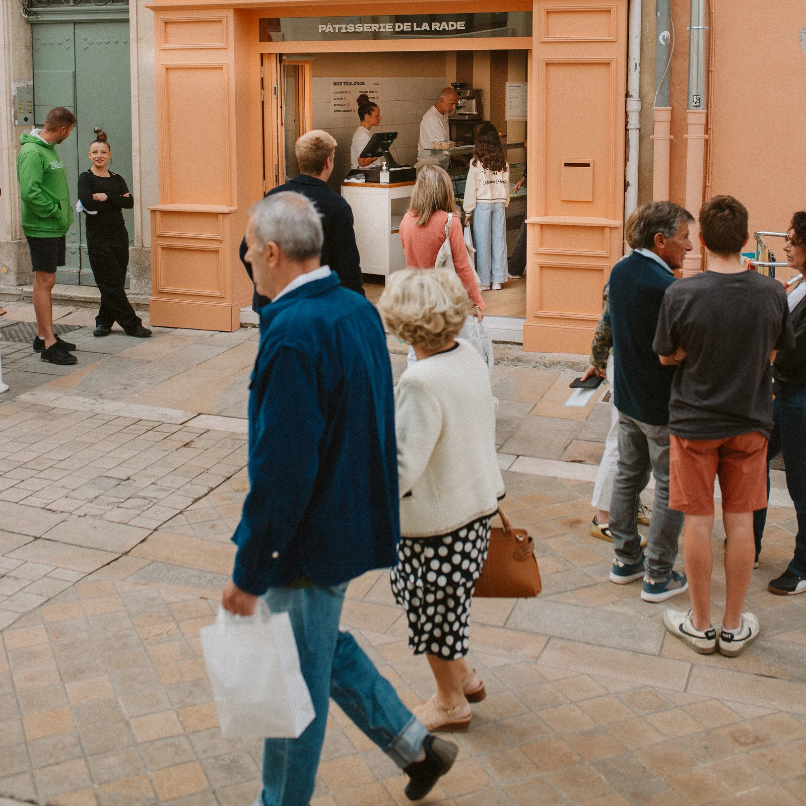 Façade de la boutique Ô’Toulong avec des clients faisant la queue